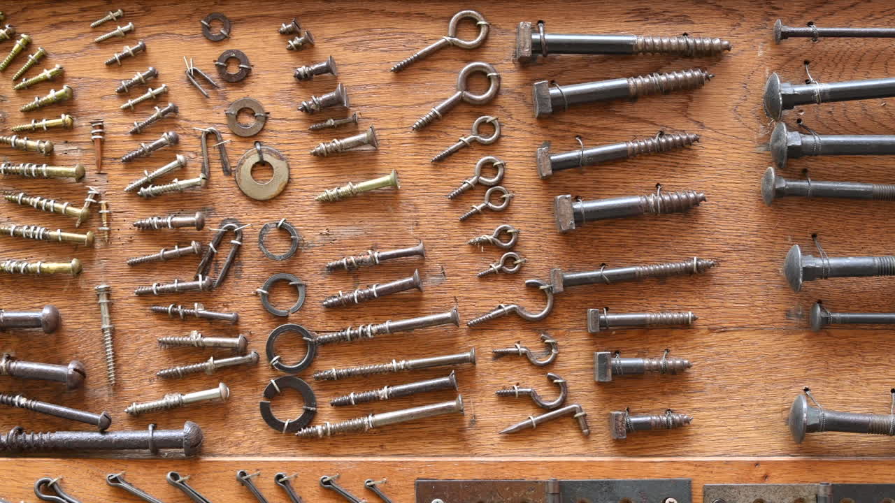 Different types of screws and other instruments in a wooden tool box