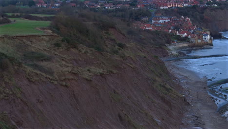 Aerial-Drone-Shot-of-Sedimentary-Cliffs-and-Robin-Hood's-Bay-Yorkshire