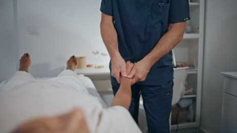 physiotherapist treating patient rehabilitation closeup. man examining hand