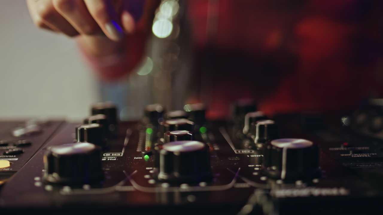 DJ hand using mixer expertly controlling nightclub rhythm closeup. Woman mixing