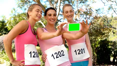 young female athletes clicking photo from mobile phone