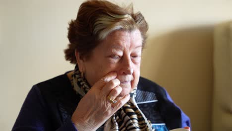 granny applying anti-wrinkle cream on her face to take care of her skin