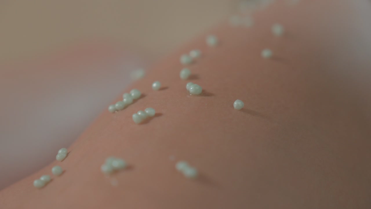 마사지 전에 클라이언트의 다리에 있는 작은 알로에 베라 구슬의 클로즈업