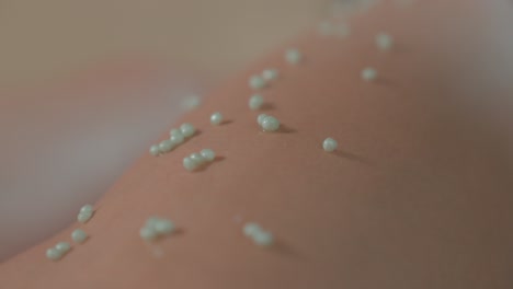 Close-up-shot-of-small-beads-of-aloe-vera-on-a-client-leg-before-a-massage