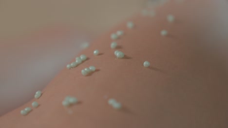 fotografía de cerca de pequeñas cuentas de aloe vera en la pierna de un cliente antes de un masaje