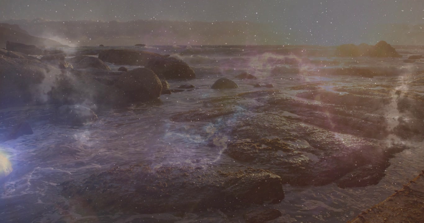 Gentle swell causing waves lapping over rocks, foam and shimmering lens flares showcasing interplay