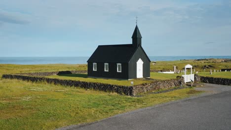 budakirkja church in snaefellsjoekull national park, iceland. aerial drone circle footage.