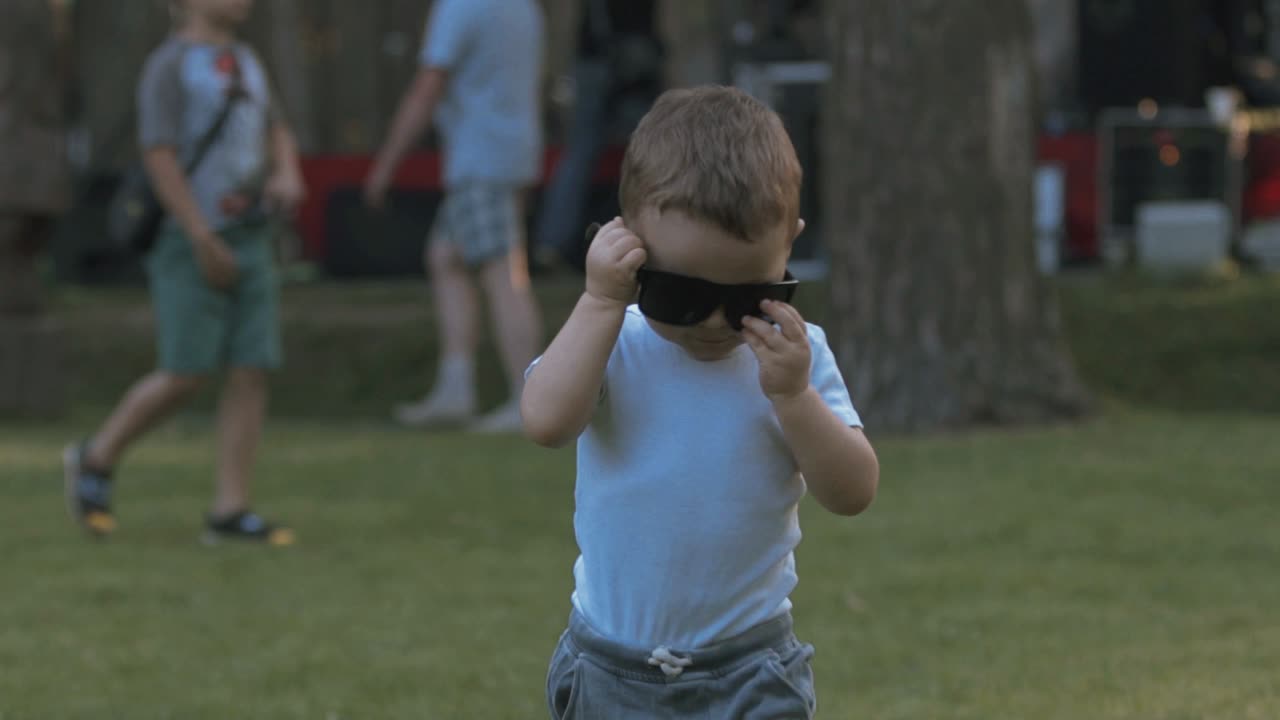 선글라스를 입은 아이가 느린 동작을 하고 있습니다.