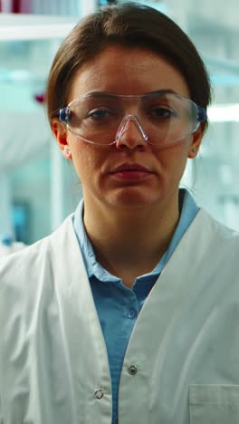 vertical video: close up of scientist nurse looking tired at camera