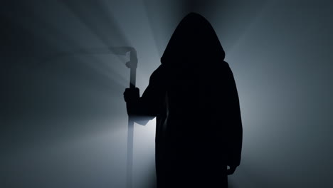Silhouette-grim-reaper-waiting-with-scythe-indoors.-Scytheman-standing-darkness.