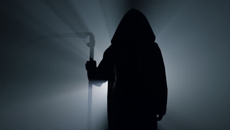 silhouette grim reaper waiting with scythe indoors. scytheman standing darkness.