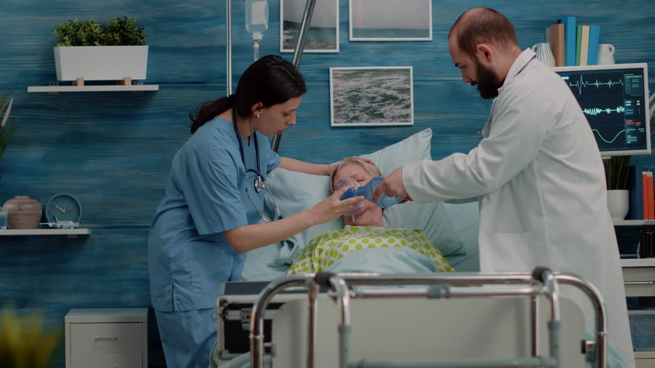 Doctor and nurse helping elder patient with disease in bed