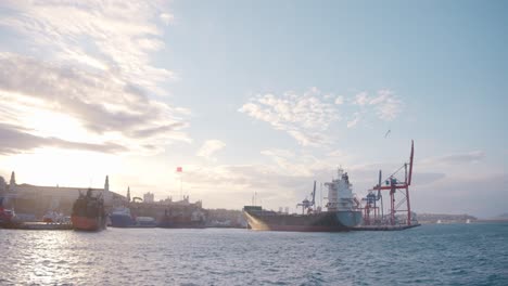 ships and cranes in a port at sunset