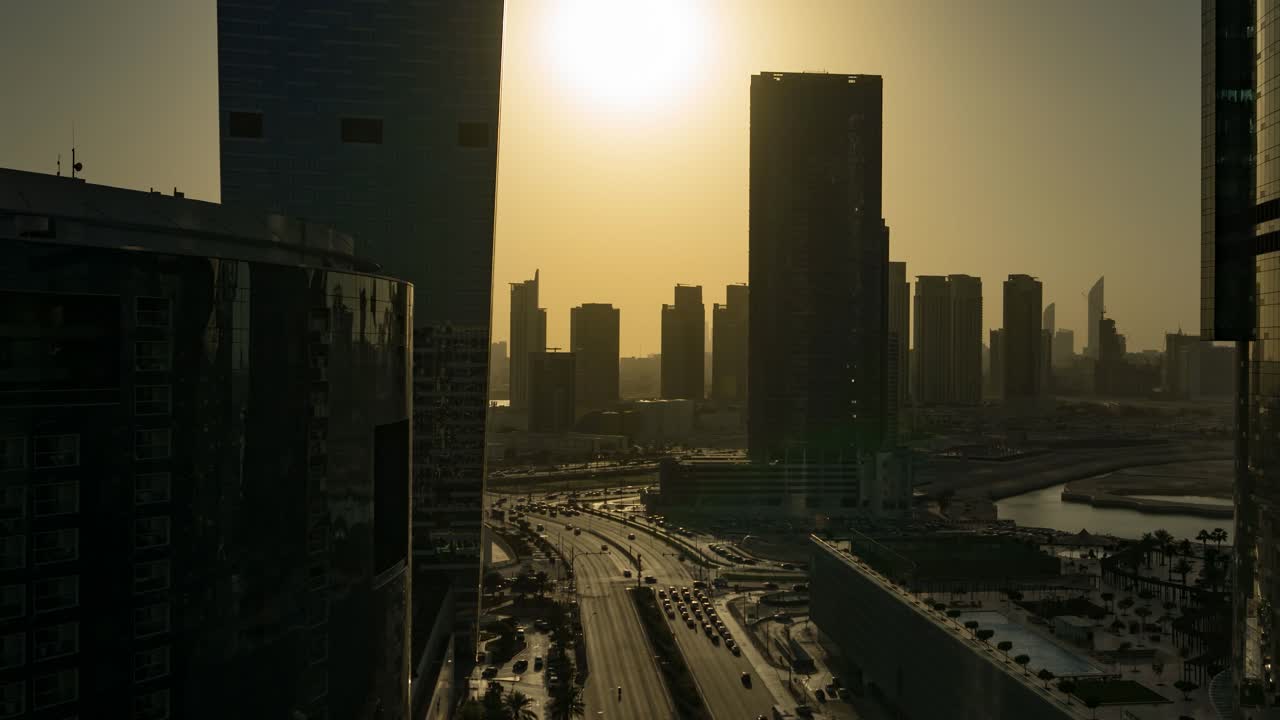 Abu Dhabi city skyline and traffic in the United Arab Emirates from sunset to nighttime - panning time lapse