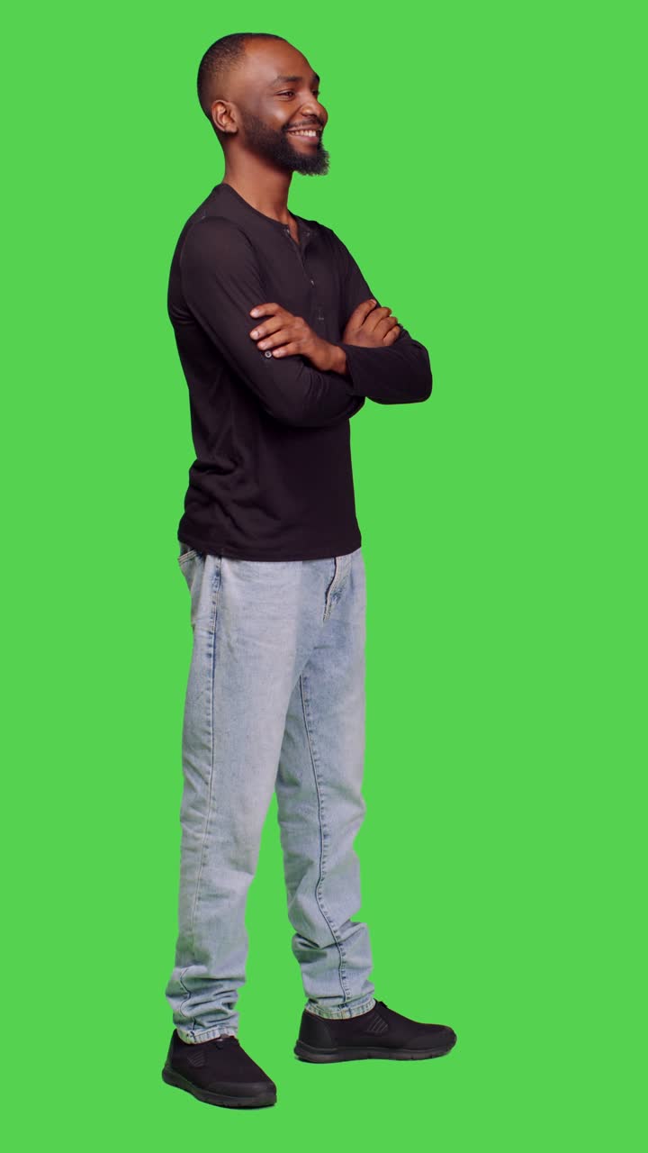 Vertical video: Side view of african american person smiling in studio and posing