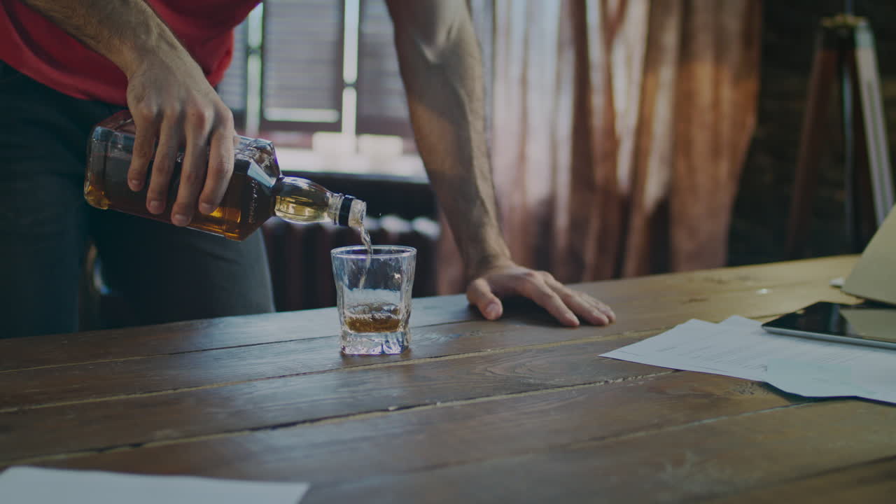 Bottiglia di whisky che versa in un bicchiere. Versare bevande alcoliche. Whisky Jack Daniel's.