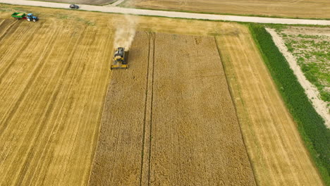 Combine-harvester-moving-through-wheat-field,-close-up-on-machinery-cutting-crops