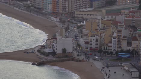 Ciudad-De-Blanes-En-La-Costa-Brava-De-España,-Playa-Turística-Ciudad-Puesta-De-Sol-E-Imágenes-Nocturnas-Vistas-Desde-La-Playa-Principal-Aérea