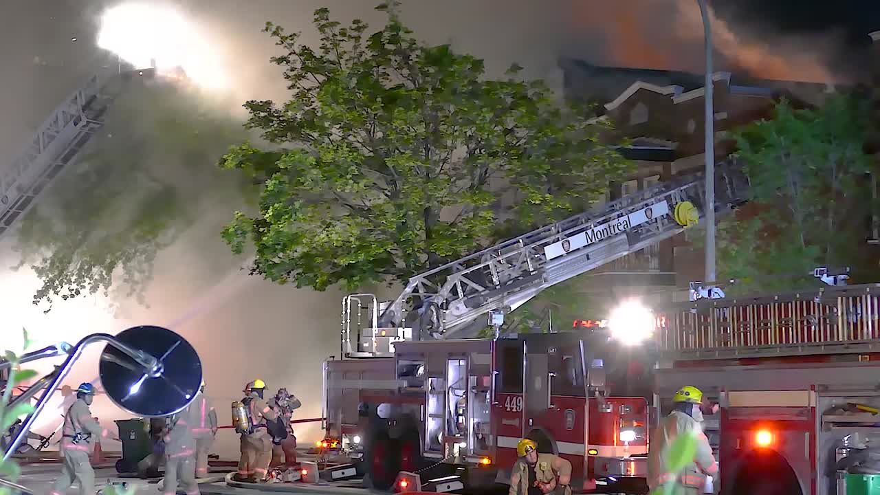 Firefighters extinguishing a fire as smoke billows from the building