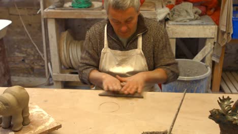 male potter molding a clay