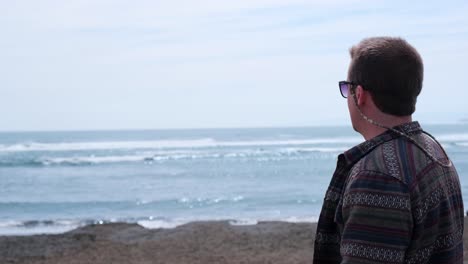 Joven-Mirando-Al-Mar-En-Un-Día-Soleado-Con-Hermosas-Olas-En-Camaralenta,-Pichilemu,-Punta-De-Lobos,-Chile