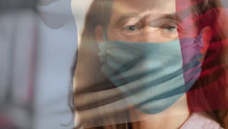 bandera francesa ondeando contra una mujer con una máscara facial