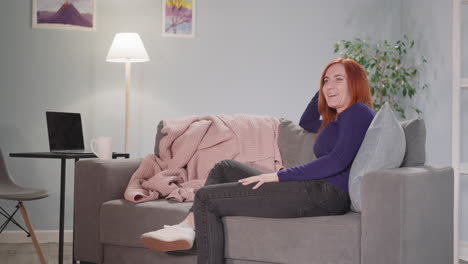 redhead housewife laughs watching funny comedy movie