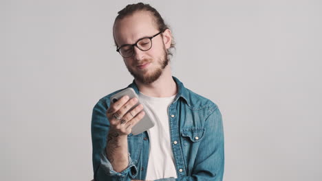 caucasian young man using smartphone on camera.