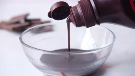 chocolate sauce pouring into a bowl