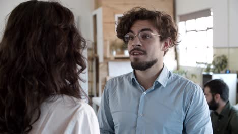Smiling-bearded-man-in-eyeglasses-talking-with-young-woman