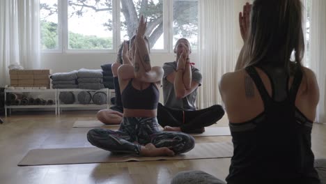 personas descalzas practicando yoga en interiores