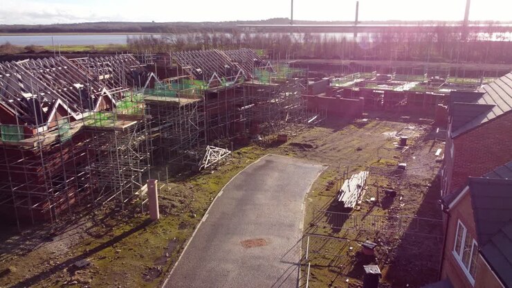 Aerial view across unfinished waterfront townhouse property development framework on building construction site