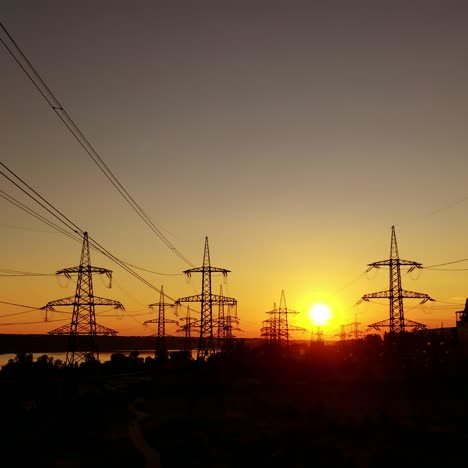 dark electric towers against beautiful sunset. high-voltage electric lines in the evening on red and yellow sky.