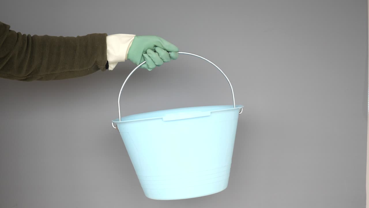 mano con un cubo de plástico azul claro