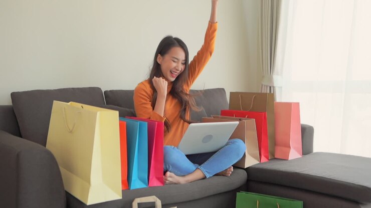 Donna felice con laptop che fa shopping online da casa.