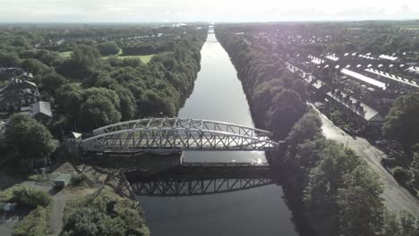 aerial push in view scenic old vintage steel archway traffic crossing footbridge over manchester ship canal