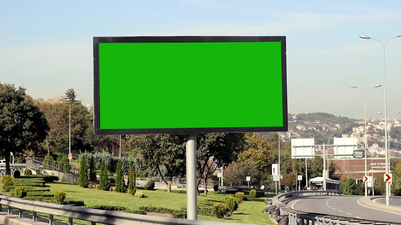 pantalla verde de cartelera publicitaria en los márgenes de la autopista con tráfico