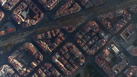 Birds-eye-of-broad-avenue-Avinguda-Diagonal-passing-through-urban-borough.-High-angle-view-of-blocks-of-buildings-lit-by-low-sun.-Barcelona,-Spain