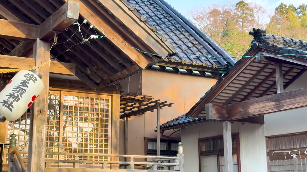 Wind moves a white paper lantern hanging from a historic wooden Japanese shrine building