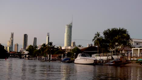 boats docked along canal with city skyline