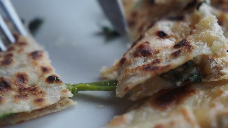 Cutting a Piece of Traditional Gözleme Flatbread with Filling