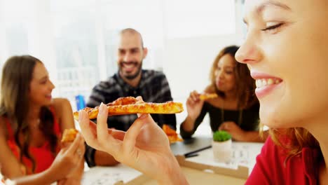 ejecutivos felices compartiendo pizza en la sala de conferencias