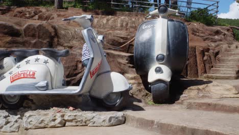 Turista-Femenina-Visitando-La-Escultura-Gigante-De-Scooter-De-Arcilla-En-El-Túnel-De-Arcilla-En-D-Alat,-Vietnam