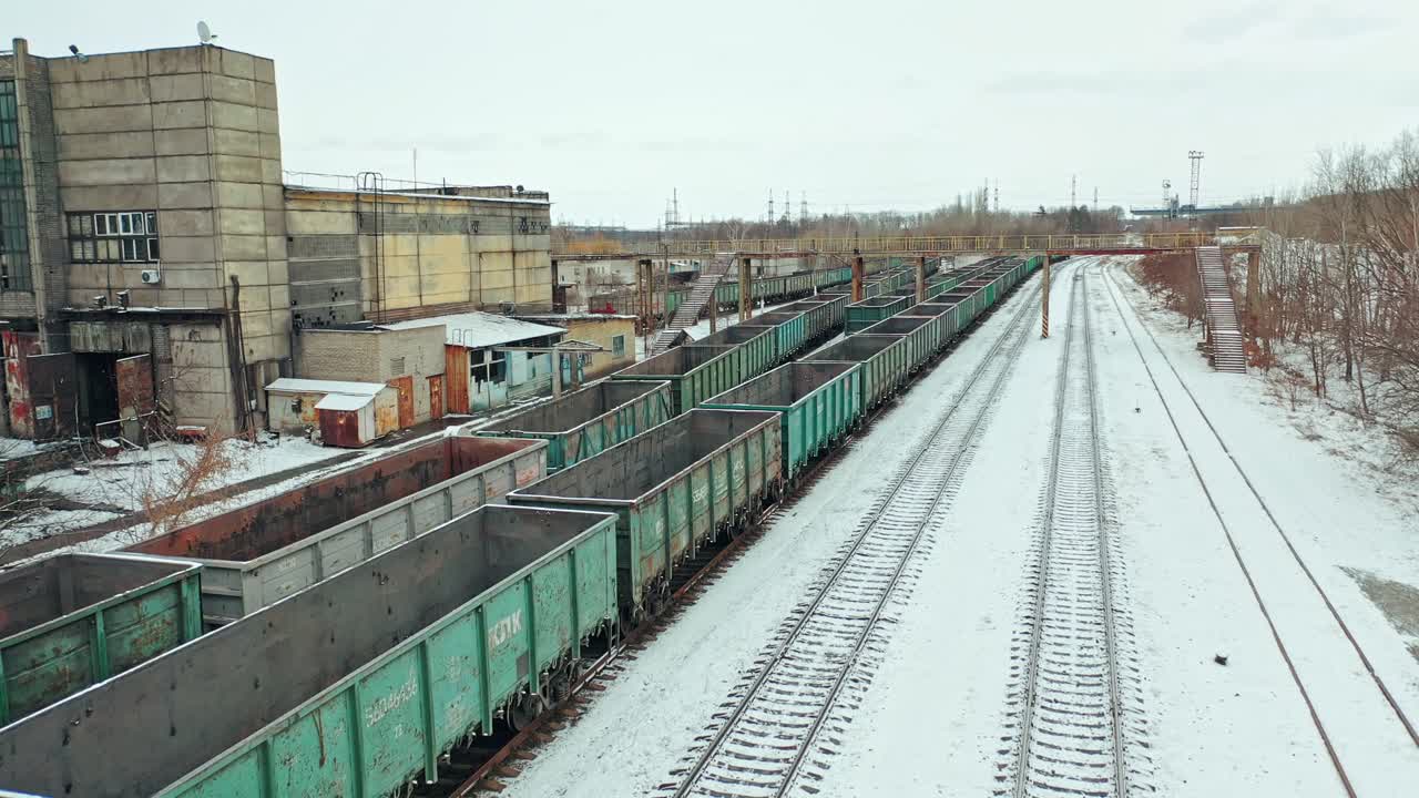 Four rows of containers are located at the railway station near the state building outside the city. Aerial view.