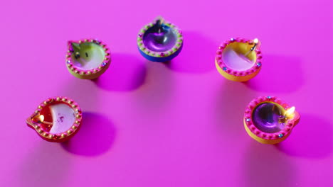 primer plano de las velas coloridas que queman celebrando diwali sobre un fondo púrpura