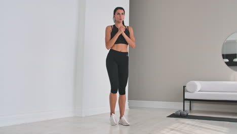beautiful fit girl doing home workout performing lateral lunges in a sitting room