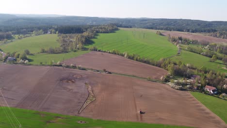 drone zoom out capturing top view of farmland layout and horizon with planting areas in czech republic