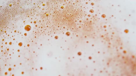 detailed view of bursting beer bubbles, effervescence and industrialized beverages