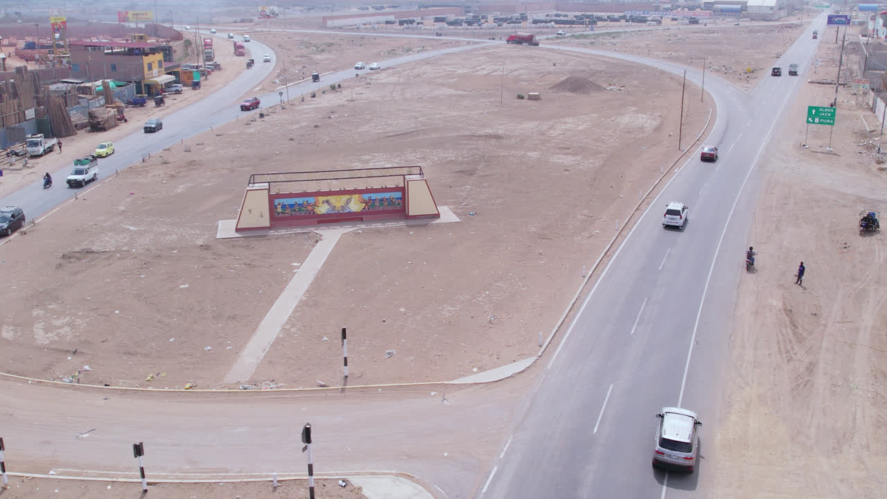 자동차가 고속도로를 지나가는 동안 페루의 치클라요 시 입구의 드론으로 공중 장거리 촬영