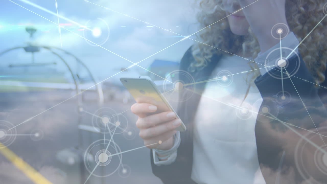 animación de procesamiento de datos y nubes sobre una mujer de negocios caucásica que usa un teléfono inteligente